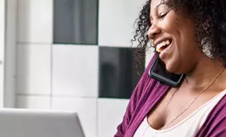 Customer experience - Female talking on phone using laptop