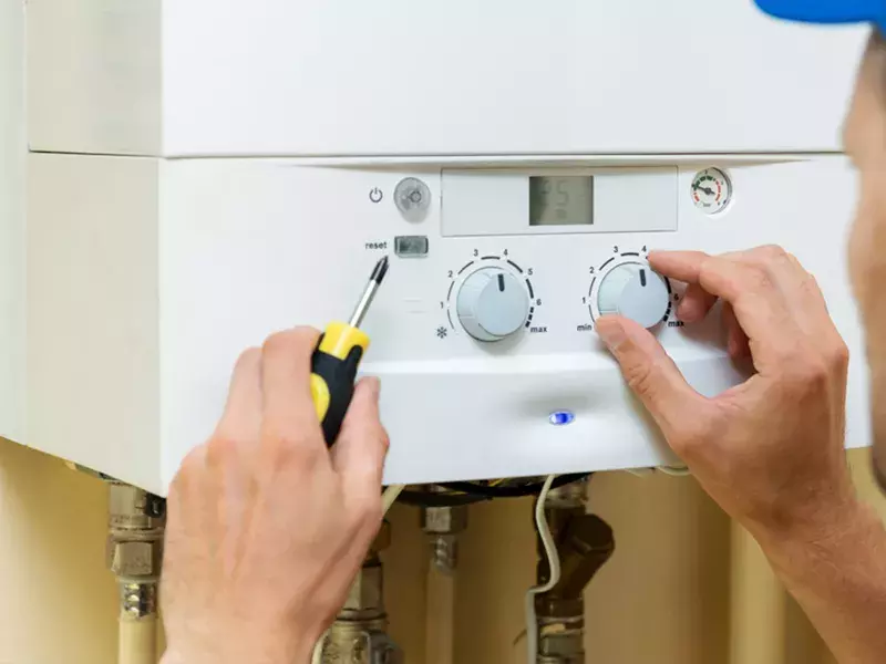 Worker set up central gas heating boiler at home