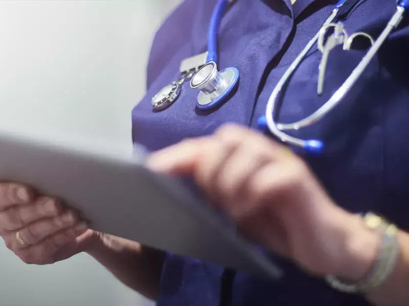 Healthcare professional holding a tablet device