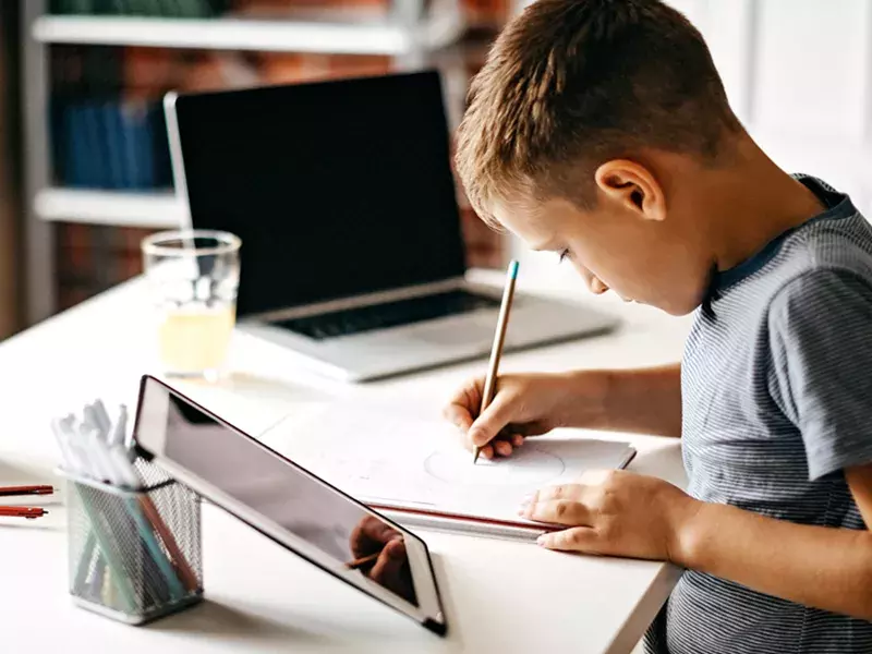 Child writing on a notepad