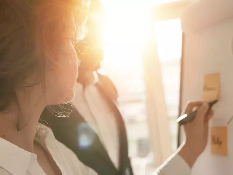 Women writing on post it note