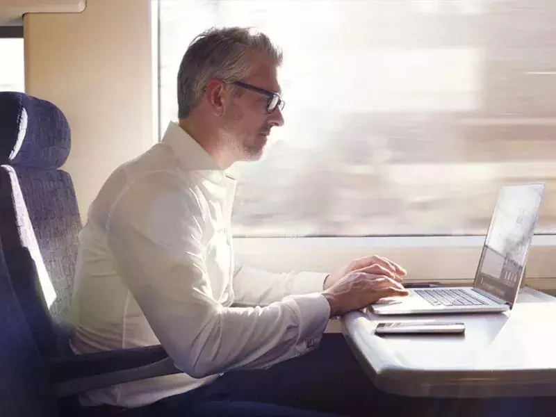 man with laptop in train