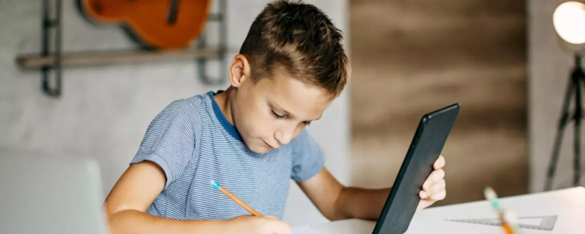 Kid learning for exam on digital tablet and laptop