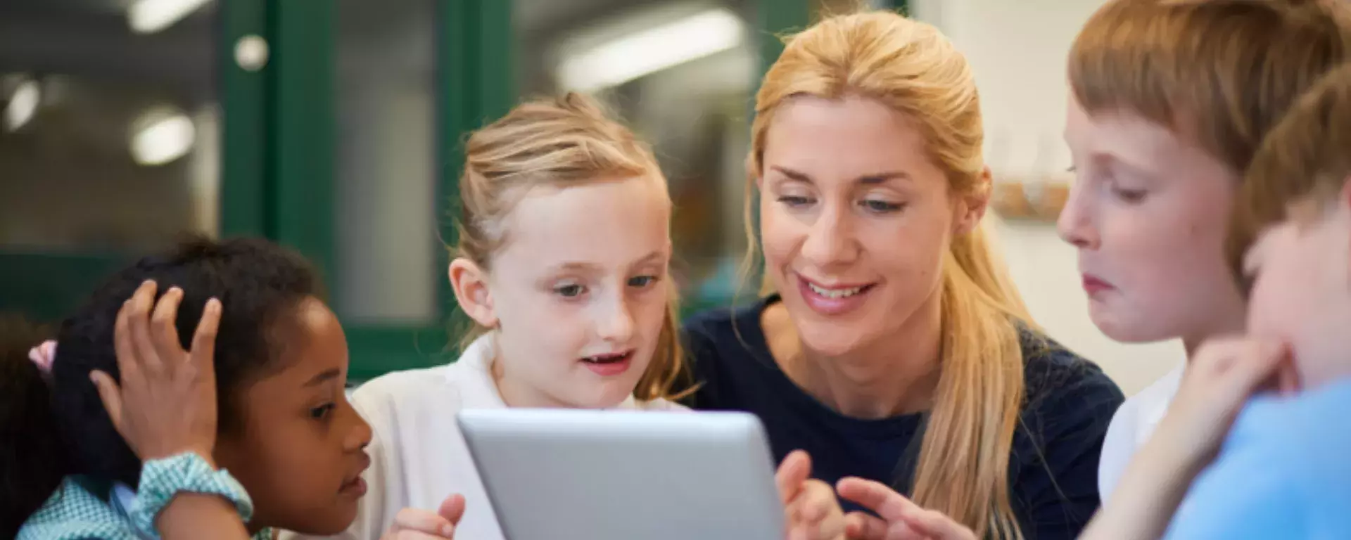 Teacher with students using laptop